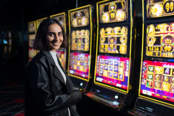 A woman smiling while playing online games on her laptop, surrounded by neon casino elements, showcasing 3333DET’s diverse game collection.